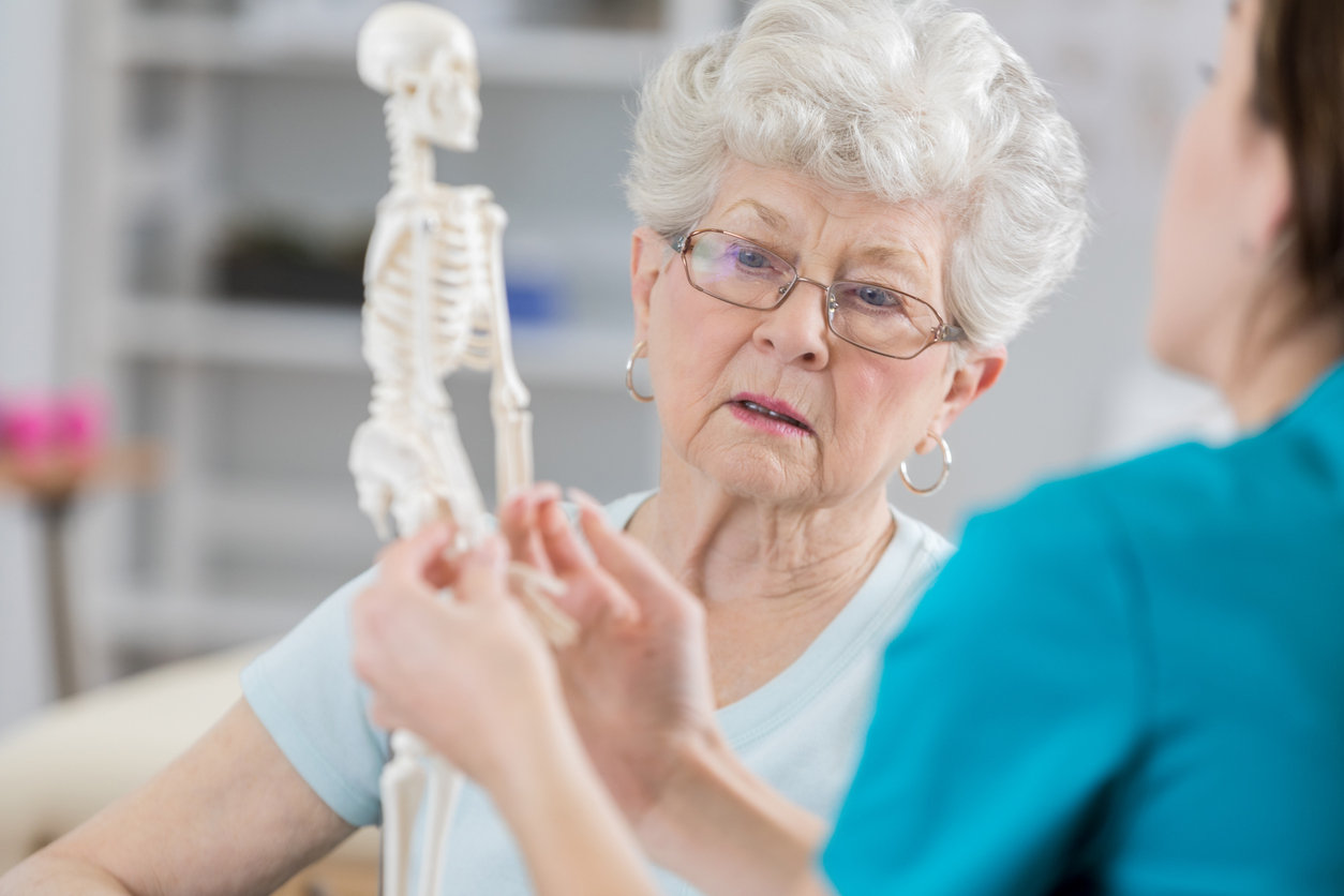 doctor showing the effects of osteoporosis